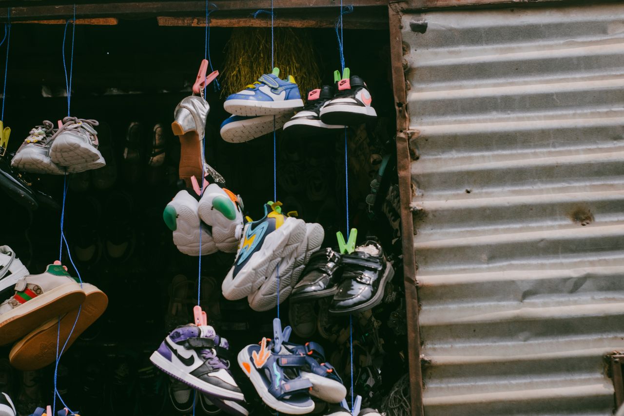 Colorful sneakers hanging for sale in an outdoor street market.